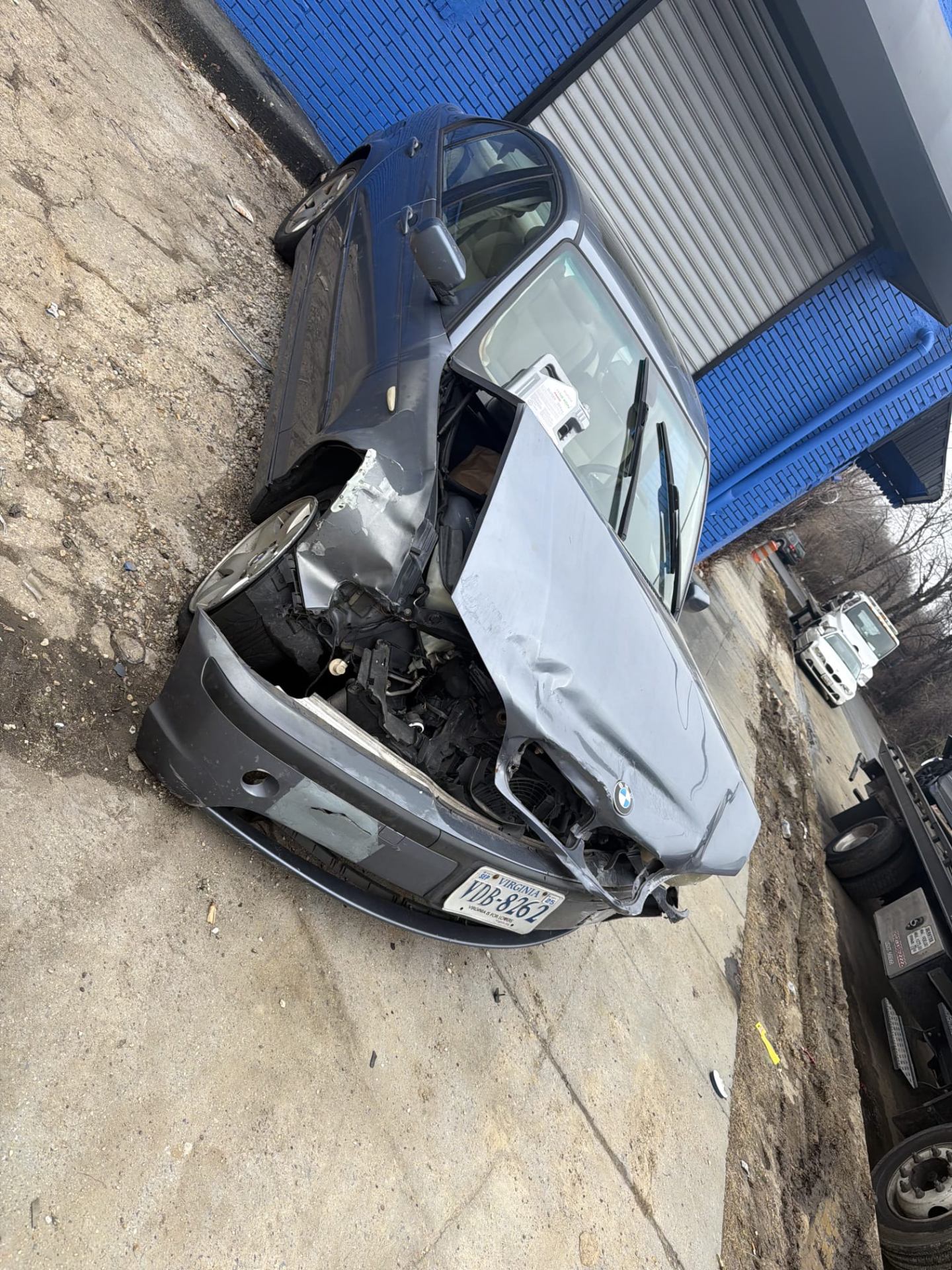 Wrecked BMW sedan with major front-end damage at a Northern Virginia recycling facility