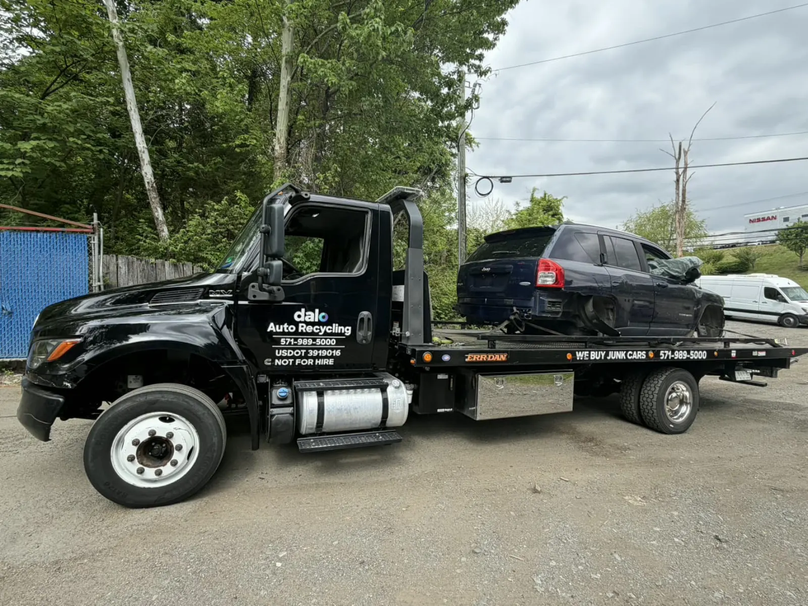 Damaged SUV loaded onto a Dalo Auto Recycling flatbed truck in Annandale, VA