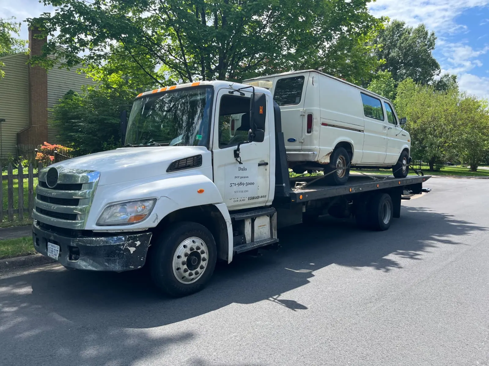 Dalo Auto Recycling flatbed tow truck serving Dumfries, VA with an older van loaded for pickup