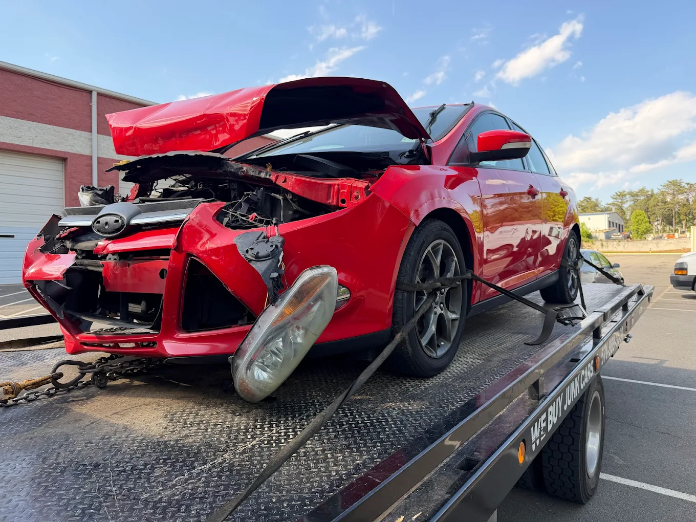 Wrecked red car loaded for junk car removal in Fairfax, VA