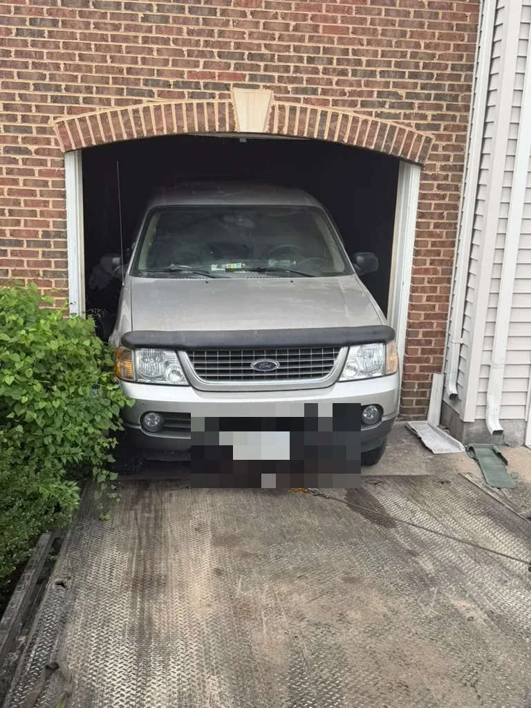 SUV being winched from a residential garage in Falls Church, VA by Dalo Auto Recycling