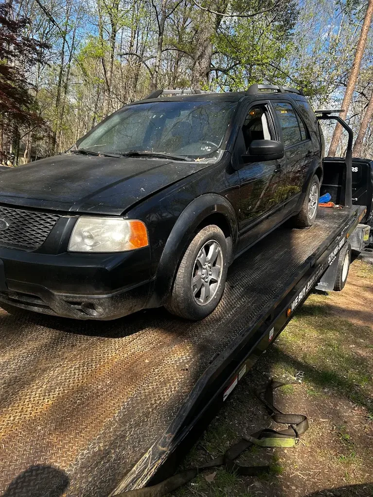 SUV loaded onto a flatbed tow truck during a vehicle pickup in Gainesville, VA