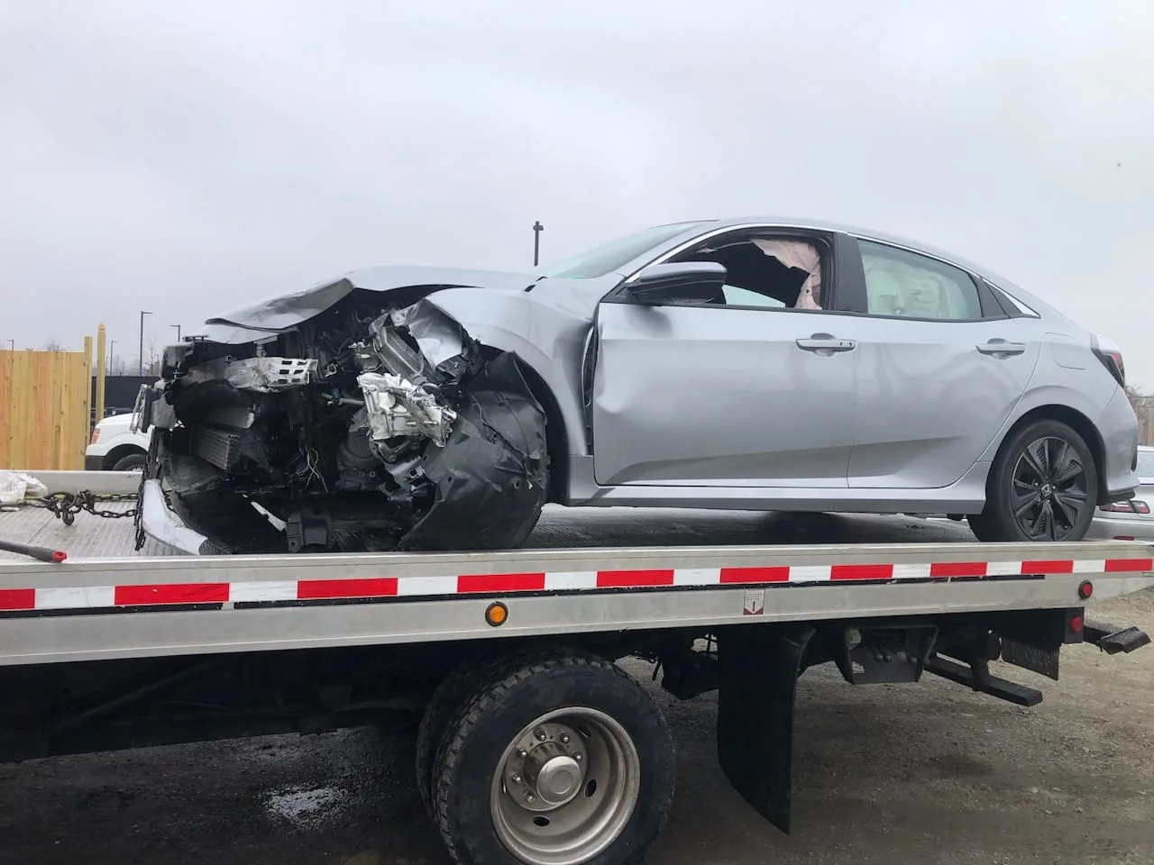 Accident-damaged Honda Civic loaded onto a flatbed truck in Herndon, VA
