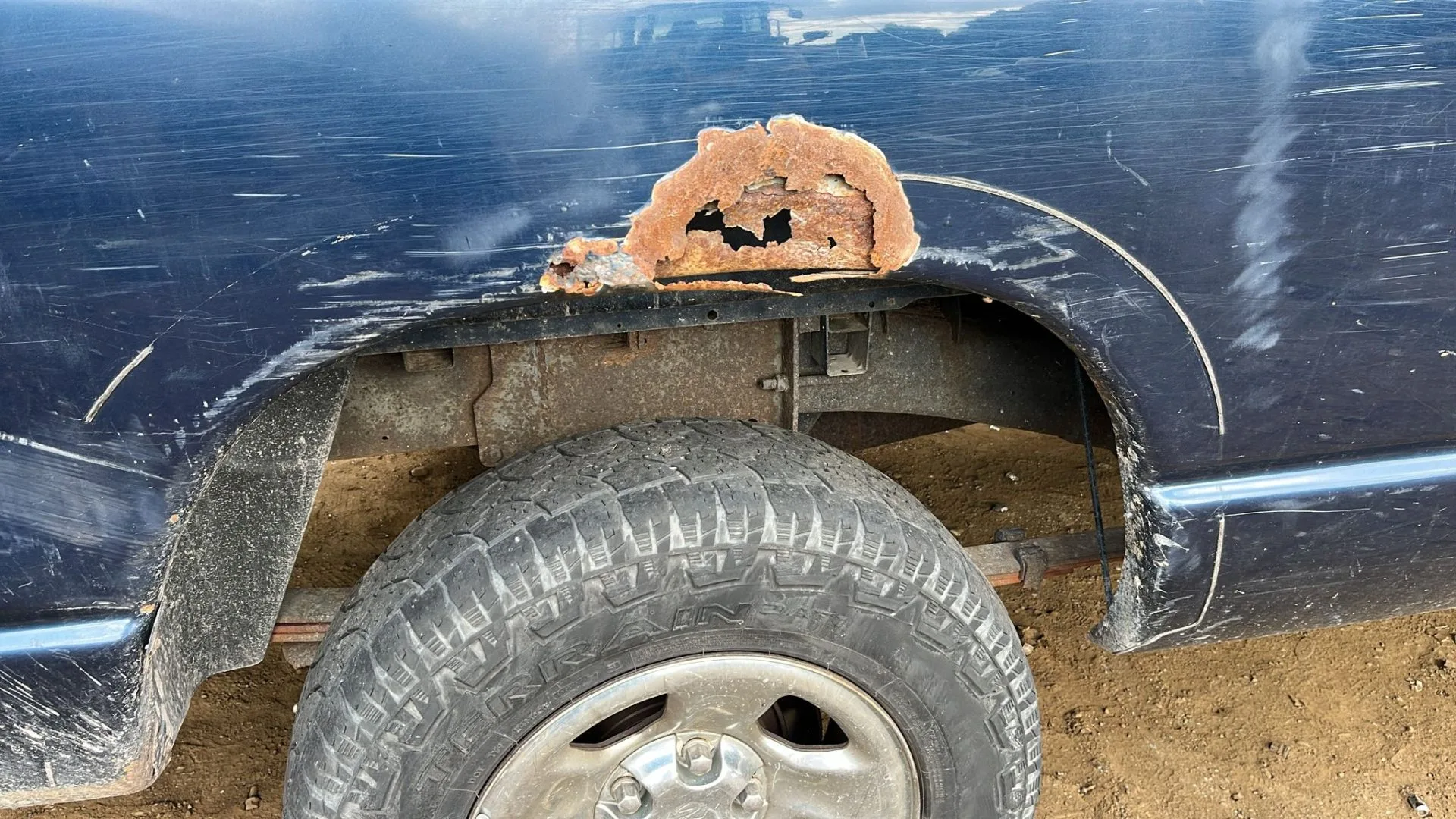 Close-up of rust-through corrosion on a Dodge Ram fender