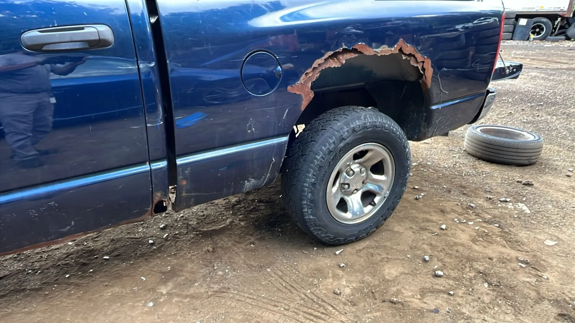 Blue Dodge Ram 1500 with severe rust hole through the rear bedside — a Northern Virginia commuter truck
