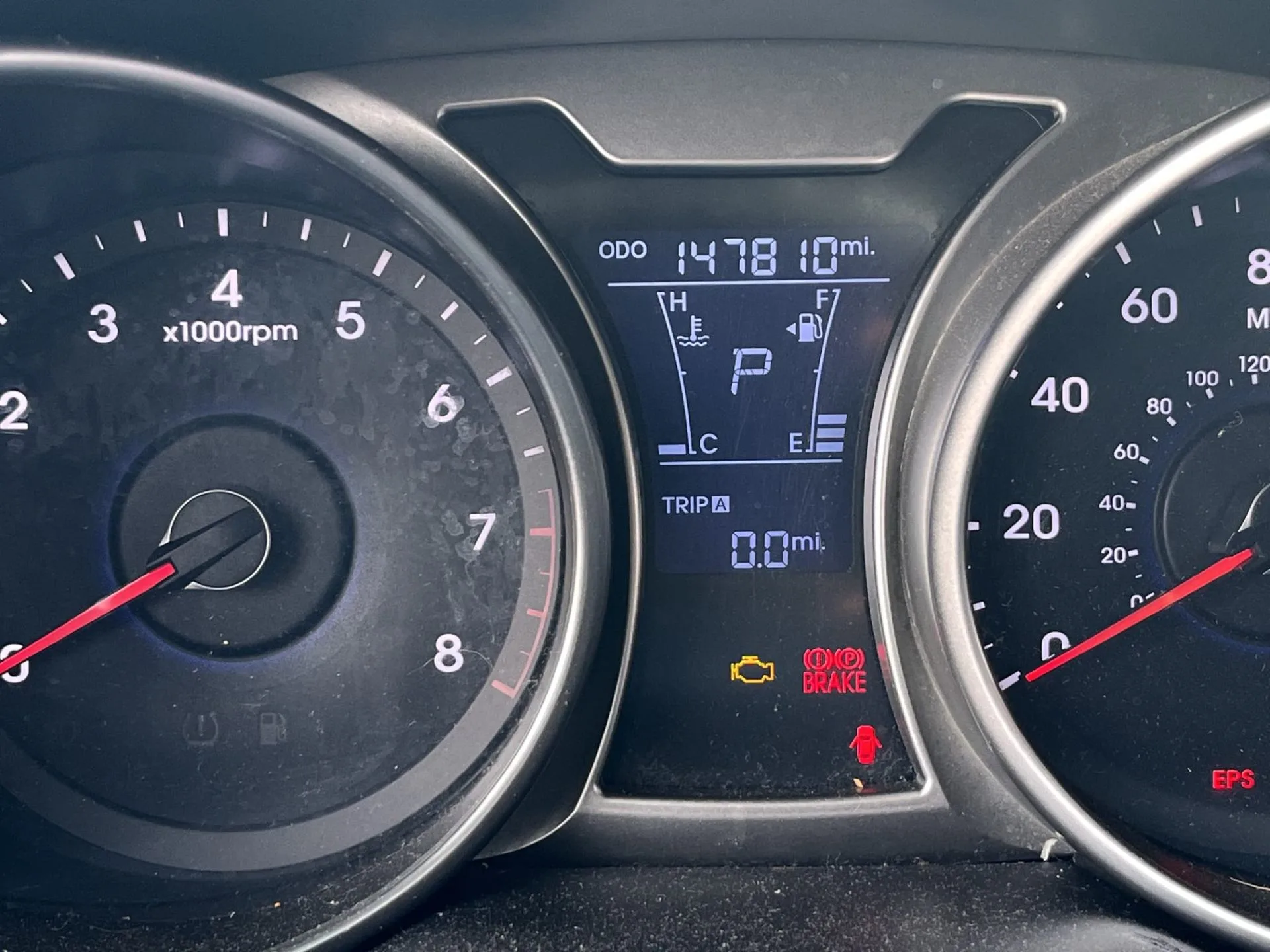 Check engine light glowing on the instrument cluster of a high-mileage commuter car